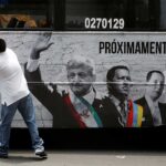 A man tears an advertising campaign featuring leftist front-runner Andres Manuel Lopez Obrador (L) of the National Regeneration Movement (MORENA) alongside Latin American leaders Hugo Chavez and Lula in Mexico City, Mexico April 25, 2018. Photo: REUTERS/Ginnette Riquelme.