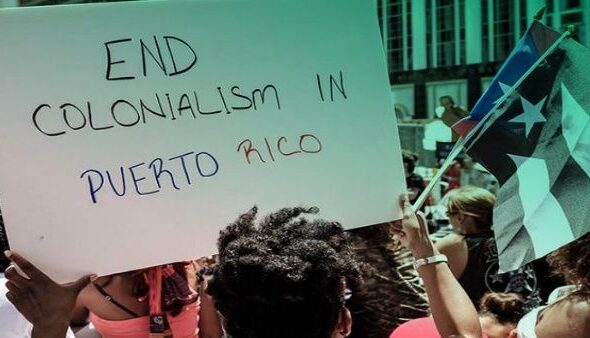 Protesters in Puerto Rico raise a banner demanding an end to US colonization of the island. Photo: Progressive International.