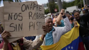 Workers protesting in Caracas against the ONAPRE guidelines. One protester holds a banner that reads "ONAPRE, you robbed us without a gun," on August 11, 2022. Photo: AP/Matias Delacroix.