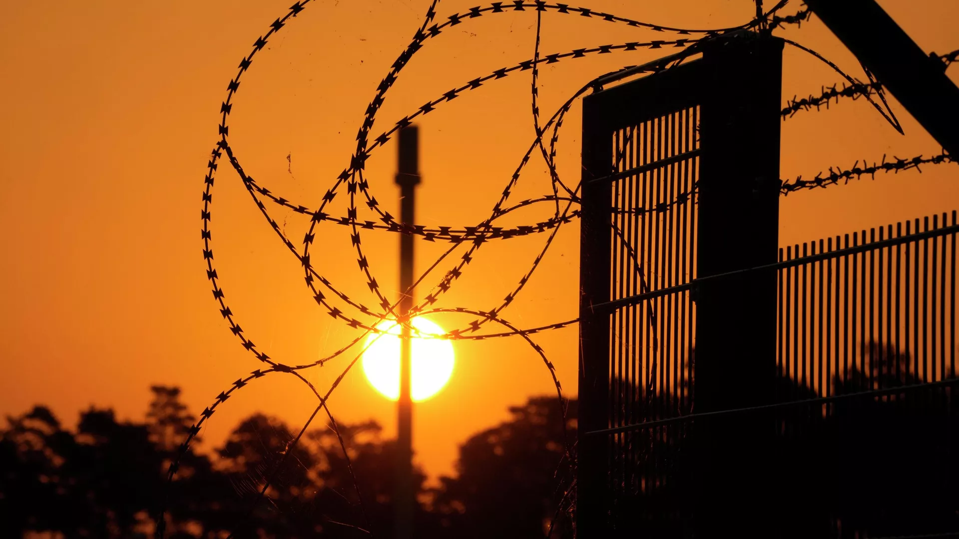 Sunset behind a wired fence. Photo: AP/Markus Schreiber.