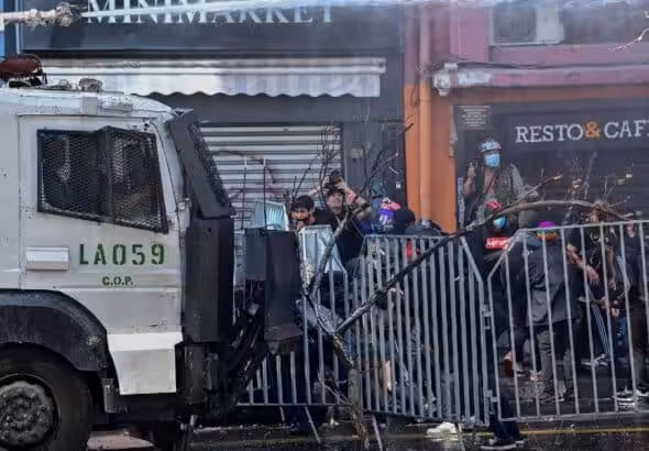Chilean police repressing young high school protesters with a water cannon. Photo: Camine.