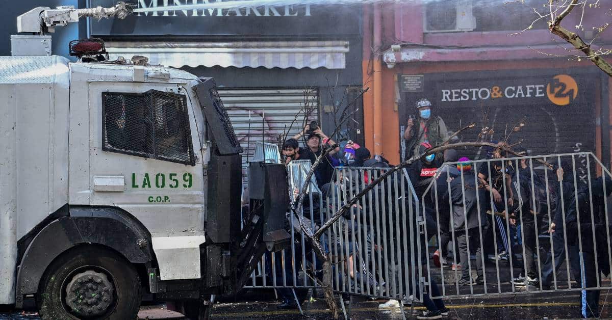 Chilean police repressing young high school protesters with a water cannon. Photo: Camine.
