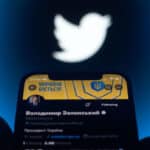 Smartphone screen showing Vladimir Zelensky Twitter account, with the Twitter logo in the background. Photo: NurPhoto via Getty Images.