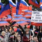 People protesting with Russian flags and with signs in Russian language. Photo: Sputnik/Konstantin Mikhalchevsky.
