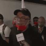 Freed Emtrasur crew members talk to reporters in an airport lobby. The 12 made a stopover in Bolivia before arriving in Venezuela.