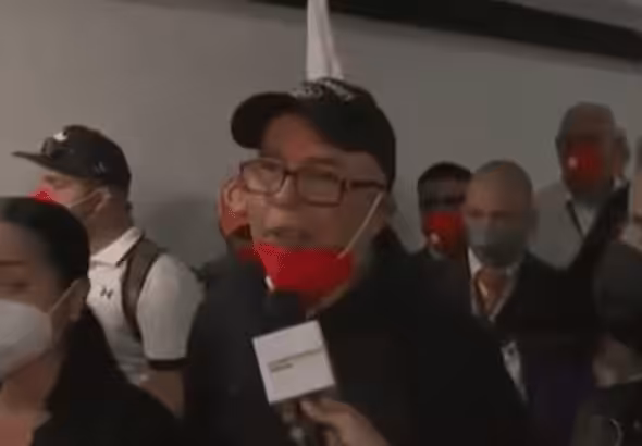 Freed Emtrasur crew members talk to reporters in an airport lobby. The 12 made a stopover in Bolivia before arriving in Venezuela.