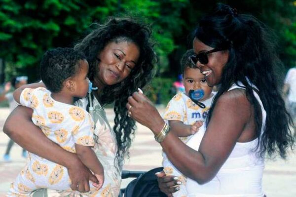 Two Afro-descendant women with babies in their arms looking very happy. File photo.