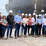 Workers of Pequiven and Monómeros, holding the Venezuelan flag in their hands, stand in front of the first ship that arrived at Monómeros from Venezuela. Photo: Twitter/@monomerossa
