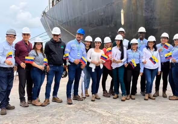 Workers of Pequiven and Monómeros, holding the Venezuelan flag in their hands, stand in front of the first ship that arrived at Monómeros from Venezuela. Photo: Twitter/@monomerossa