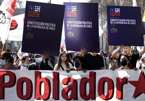 Supporters of Chile's proposed new constitution hold up placards in a street mobilization. Photo: EFE.