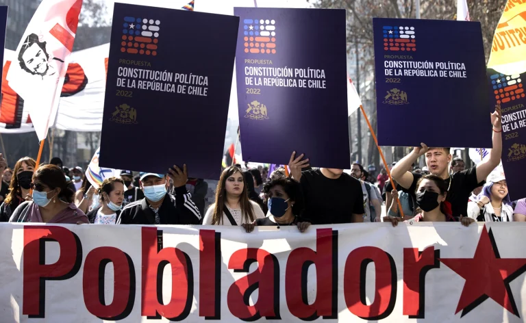 Supporters of Chile's proposed new constitution hold up placards in a street mobilization. Photo: EFE.