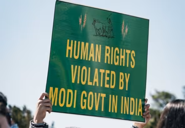 A person holds a sign that reads "Human Rights violated by Modi govt in India". Photo: Gayatri Malhotra.