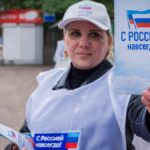 A volunteer hands out pamphlets with the message "With Russia Forever," during the campaign for the referendum to join the Russian Federation, in Lugansk, Ukraine. Photo: EFE.