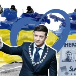Photo composition showing Ukrainian president, Vladimir Zemensky holding a baton with a blue heart behind him and a banner next to him comparing him with Vladimir Putin and showing him as a hero. Photo: metro.co.uk