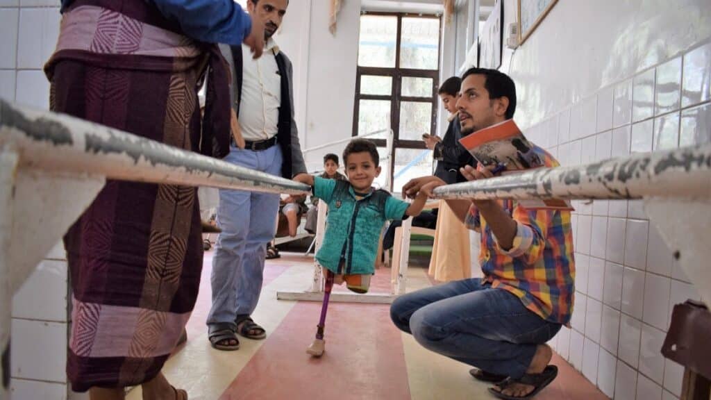 A boy learning to walk with a prostheses after losing his two legs as a result of the cruel war against the Yemeni people. Photo: Qusai/LMOAYED/ICRC.