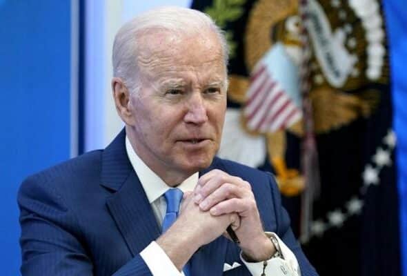 President Biden seated with hands clasped. File photo.