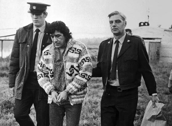 Leonard Peltier, American Indian Movement leader, is led across Oakalla Prison to a waiting helicopter, on Dec. 17, 1976, in Burnaby, British Columbia. Photo: Bettmann Archive.