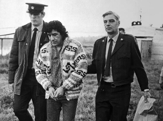 Leonard Peltier, American Indian Movement leader, is led across Oakalla Prison to a waiting helicopter, on Dec. 17, 1976, in Burnaby, British Columbia. Photo: Bettmann Archive.