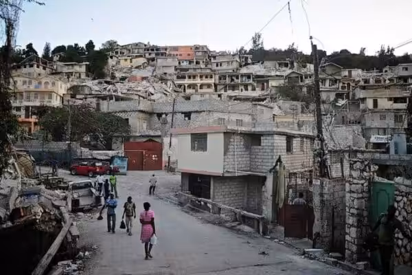 Pleople walking in a Haitian barrio that shows sign of earthquakes destruction. Photo: Colin Crowley – CC BY 2.0