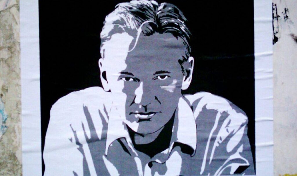 A photograph taken of a poster depicting Julian Assange. Photo: Counter Punch/Jose Mesa