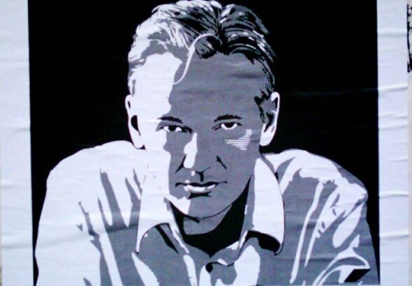 A photograph taken of a poster depicting Julian Assange. Photo: Counter Punch/Jose Mesa