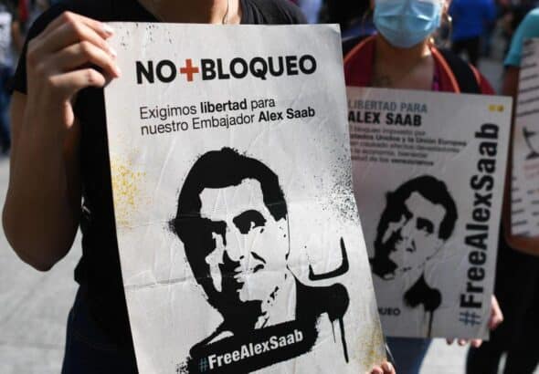 Protesters hold signs denouncing illegal US detention of Venezuelan diplomat Alex Saab. File Photo.
