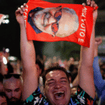 Lula supporter crying with joy while holding a big photo of Lula during a political rally. Photo: Reuters.