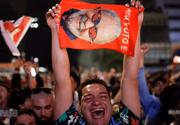 Lula supporter crying with joy while holding a big photo of Lula during a political rally. Photo: Reuters.