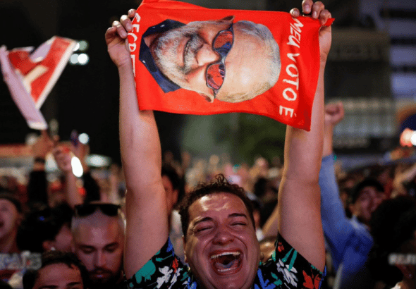 Lula supporter crying with joy while holding a big photo of Lula during a political rally. Photo: Reuters.