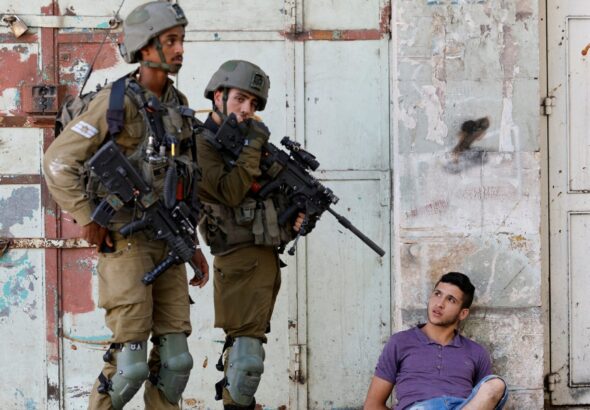 Israeli army soldiers detaining a Palestinian youth in Hebron on August 26, 2022. Photo: Reuters.