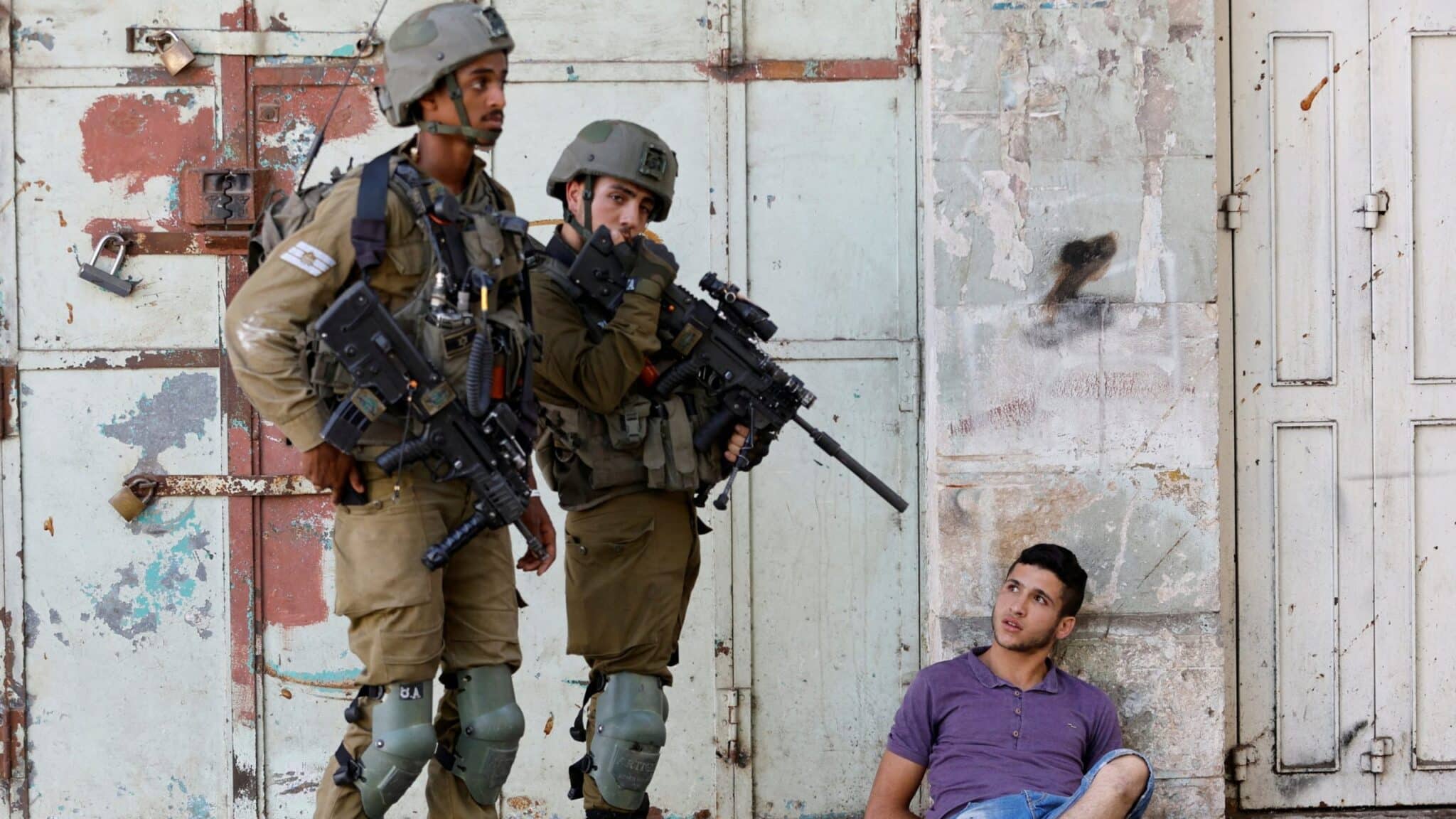 Israeli army soldiers detaining a Palestinian youth in Hebron on August 26, 2022. Photo: Reuters.