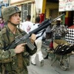 U.S. soldier on patrol in Port-au-Prince on Mar. 15, 2004, during the third U.S. military invasion of Haiti. Photo: Reuters.