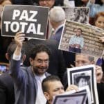 Senator Iván Cepeda holds a sign that says "Total Peace" during the installation of the new national congress. Photo: Carlos Ortega (EFF)
