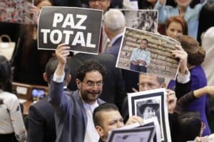 Senator Iván Cepeda holds a sign that says "Total Peace" during the installation of the new national congress. Photo: Carlos Ortega (EFF)