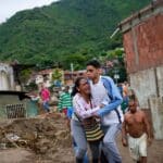 A woman screams in despair while being held by a young man with a look of shock on his face after the landslide in Las Tejerías, Aragua state, Venezuela. Photo: AP/Matías Delacroix/Via Voice of America.