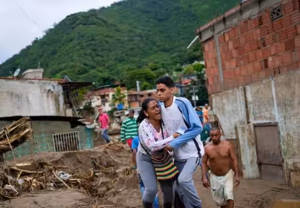 A woman screams in despair while being held by a young man with a look of shock on his face after the landslide in Las Tejerías, Aragua state, Venezuela. Photo: AP/Matías Delacroix/Via Voice of America.