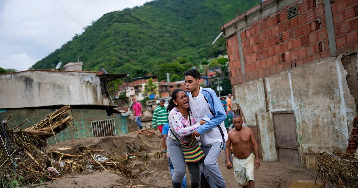 A woman screams in despair while being held by a young man with a look of shock on his face after the landslide in Las Tejerías, Aragua state, Venezuela. Photo: AP/Matías Delacroix/Via Voice of America.