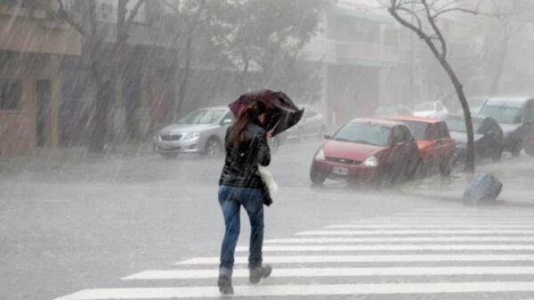 Woman on the street struggling with an umbrella in heavy rain. File photo.