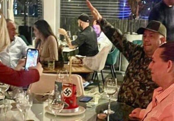 Featured image: A person doing the Nazi salute while being photograph, in front of a birthday cake with Nazi  memorabilia at the Salvaje restaurant in Las Mercedes, Caracas. Photo: Ultimas Noticias.