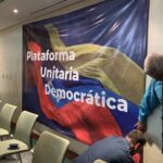 Featured image: A banner with the text "Plataforma Unitaria Democratica" (Unitary Democratic Platform) being fixed on a wall of a room before a press conference. Photo: Punto de Corte/File photo.
