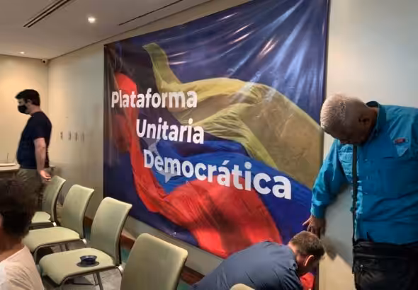 Featured image: A banner with the text "Plataforma Unitaria Democratica" (Unitary Democratic Platform) being fixed on a wall of a room before a press conference. Photo: Punto de Corte/File photo.