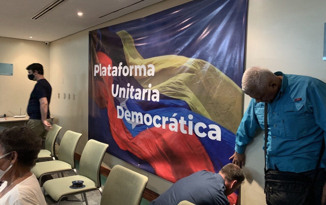 Featured image: A banner with the text "Plataforma Unitaria Democratica" (Unitary Democratic Platform) being fixed on a wall of a room before a press conference. Photo: Punto de Corte/File photo.
