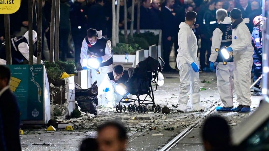 Members of a forensic team work at the detonation site, next to an abandoned baby stroller. Photo: Yasin Akgul/AFP/Getty Images.