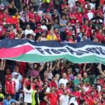 Tunisian fans unfurl a large Palestinian flag during a World Cup match in Qatar on November 26, 2022. Photo: AFP.