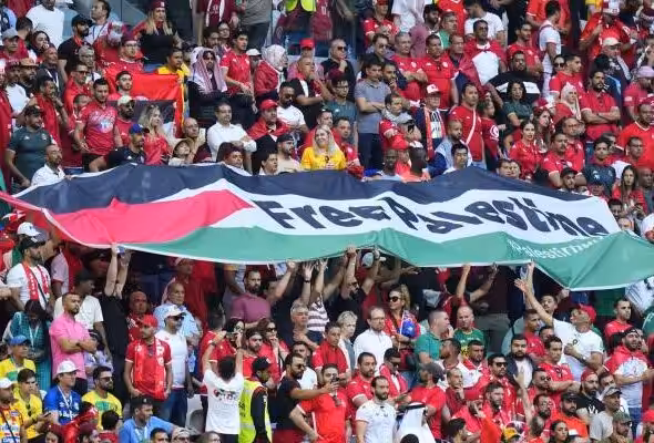 Tunisian fans unfurl a large Palestinian flag during a World Cup match in Qatar on November 26, 2022. Photo: AFP.