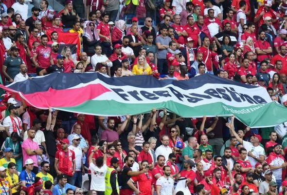 Tunisian fans unfurl a large Palestinian flag during a World Cup match in Qatar on November 26, 2022. Photo: AFP.