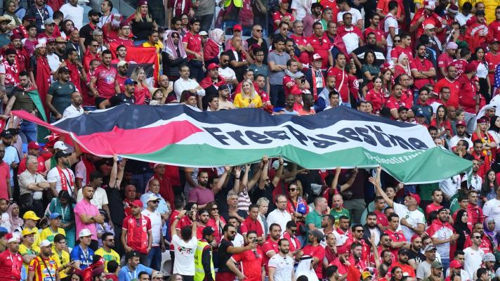 Tunisian fans unfurl a large Palestinian flag during a World Cup match in Qatar on November 26, 2022. Photo: AFP.