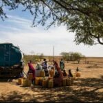 People filling up tanks with water from a truck. Photo: Vincent Tremeau.