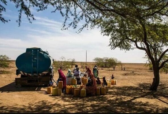 People filling up tanks with water from a truck. Photo: Vincent Tremeau.