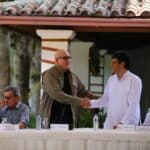 Heads of the delegations of Colombian government and ELN shake hands as they sit down to sign an agreement to restart the Colombian peace talks, in Caracas, on October 4, 2022. Photo: VTV.